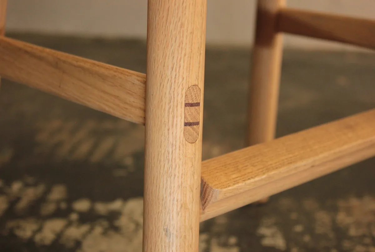 A drawbored mortise and tenon joint with contrasting timber pegs on a table frame